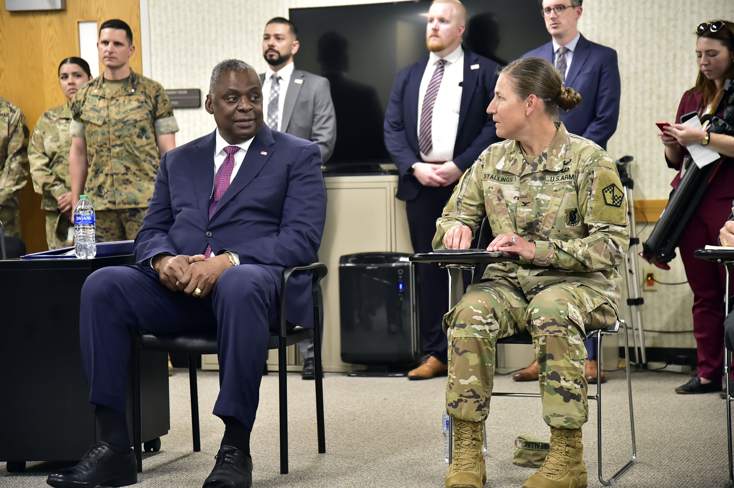 A man sits next to a female Soldier.